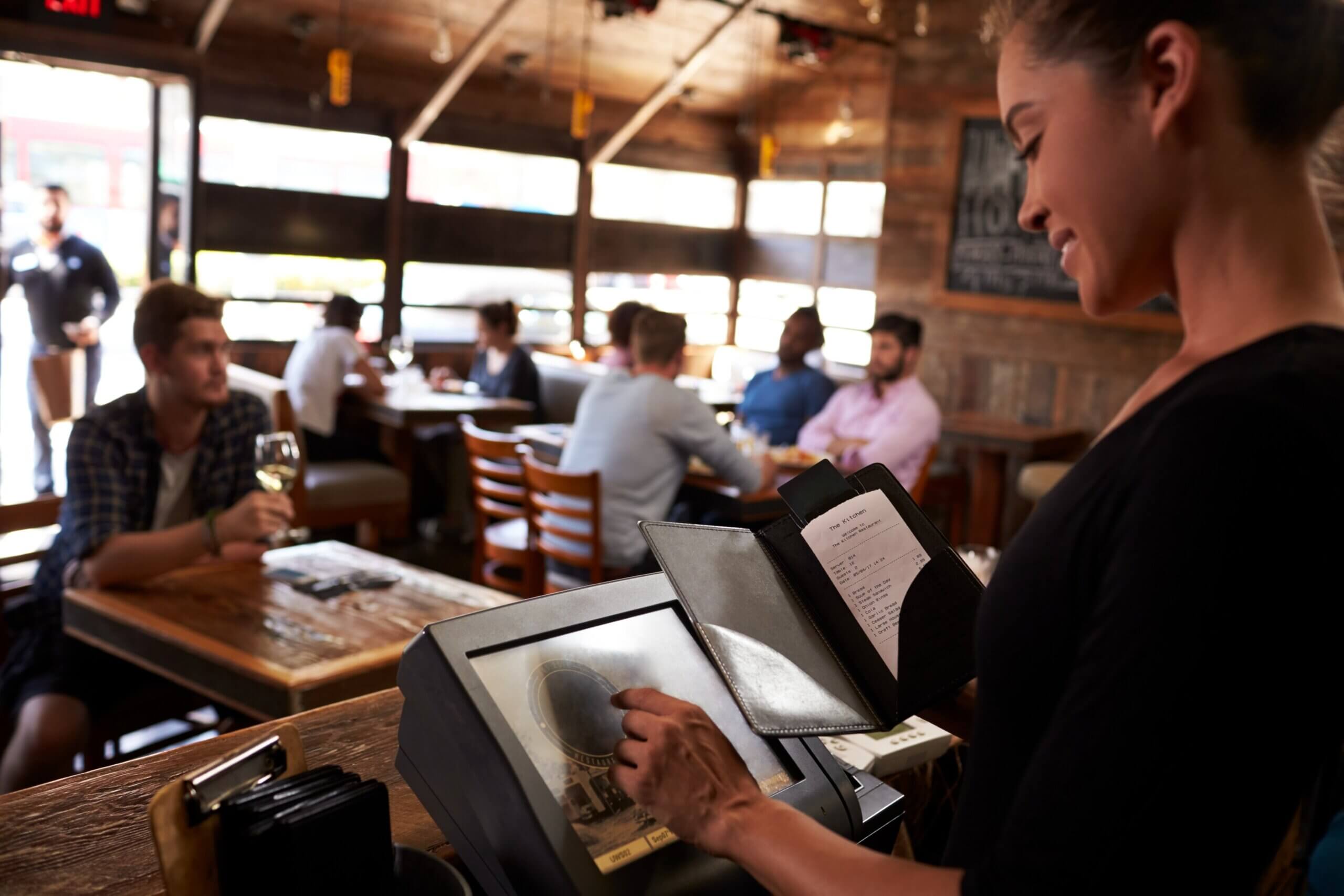 restaurant cashier using features of a restaurant POS system - fast checkout