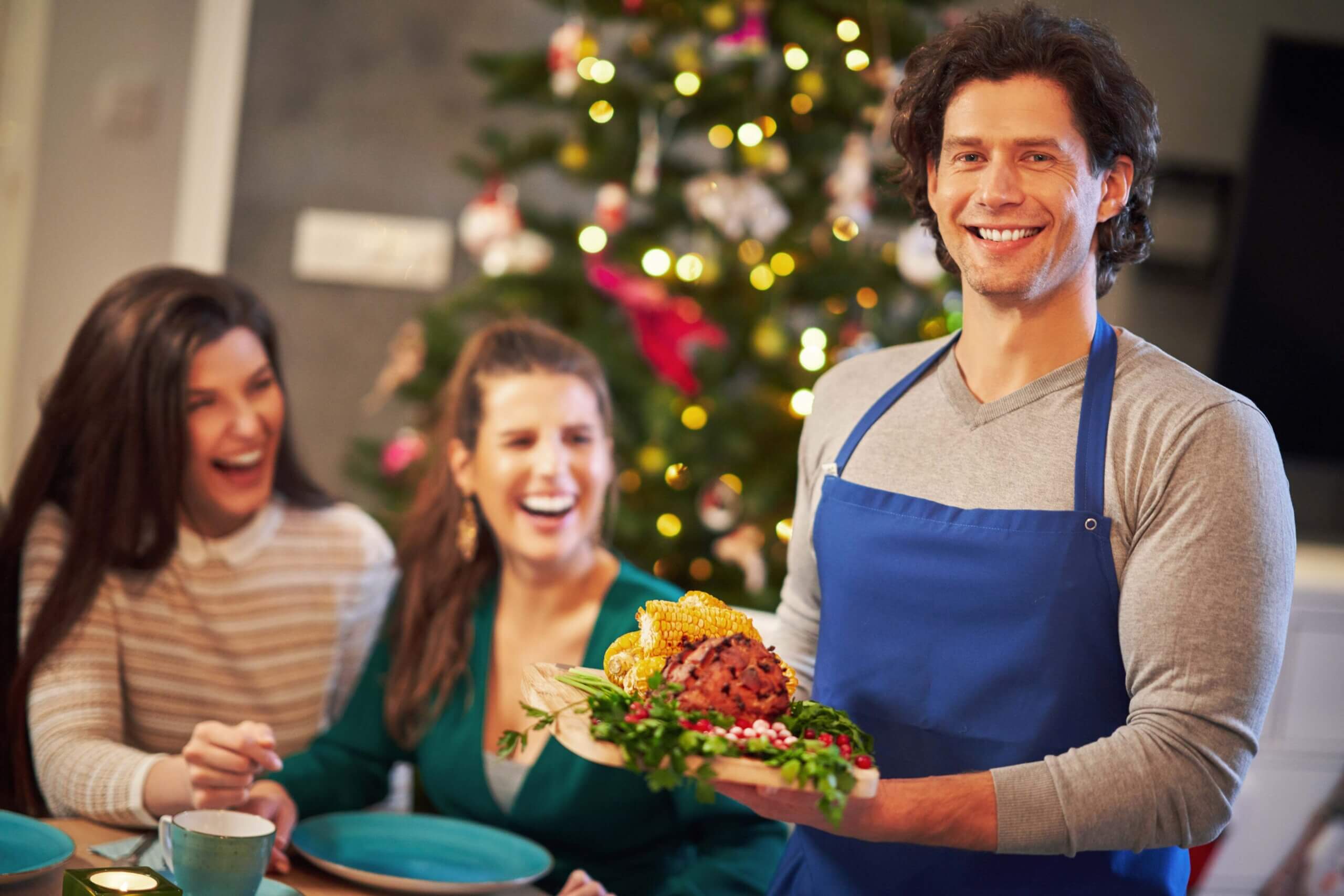 Smiling waiter serving food to happy customers in a relaxed setting
