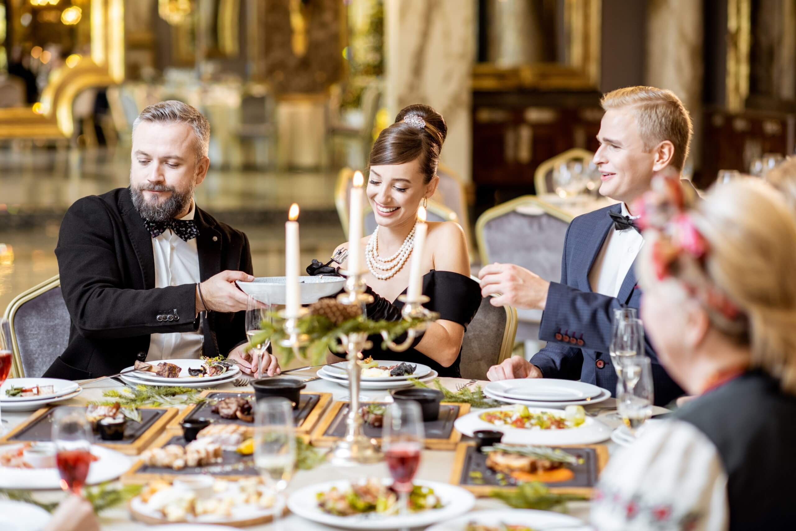 Group of people having a lively dinner with elegant decor and food.