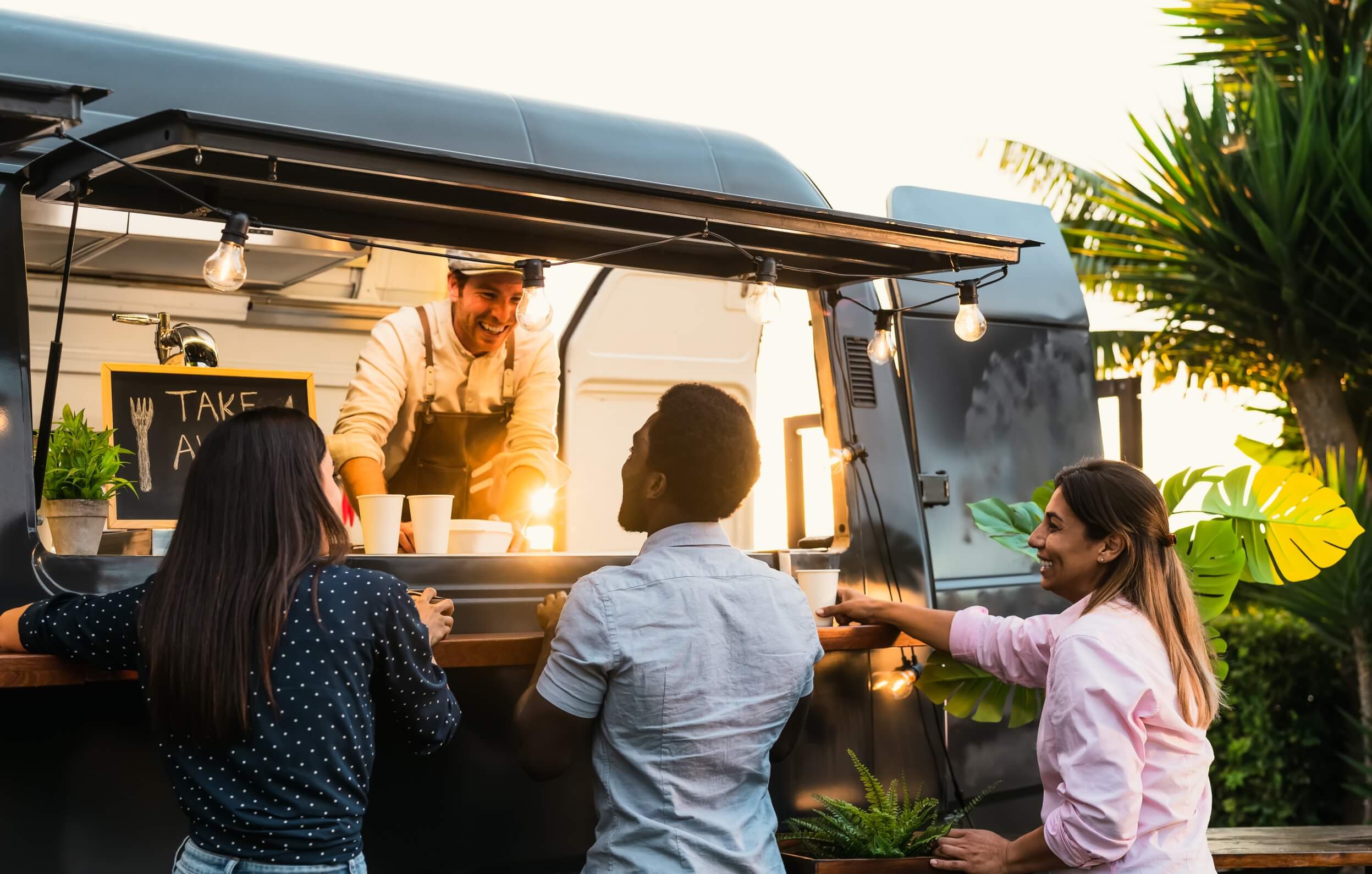 3-customers-happily-chatting-with-the-food-truck-owner