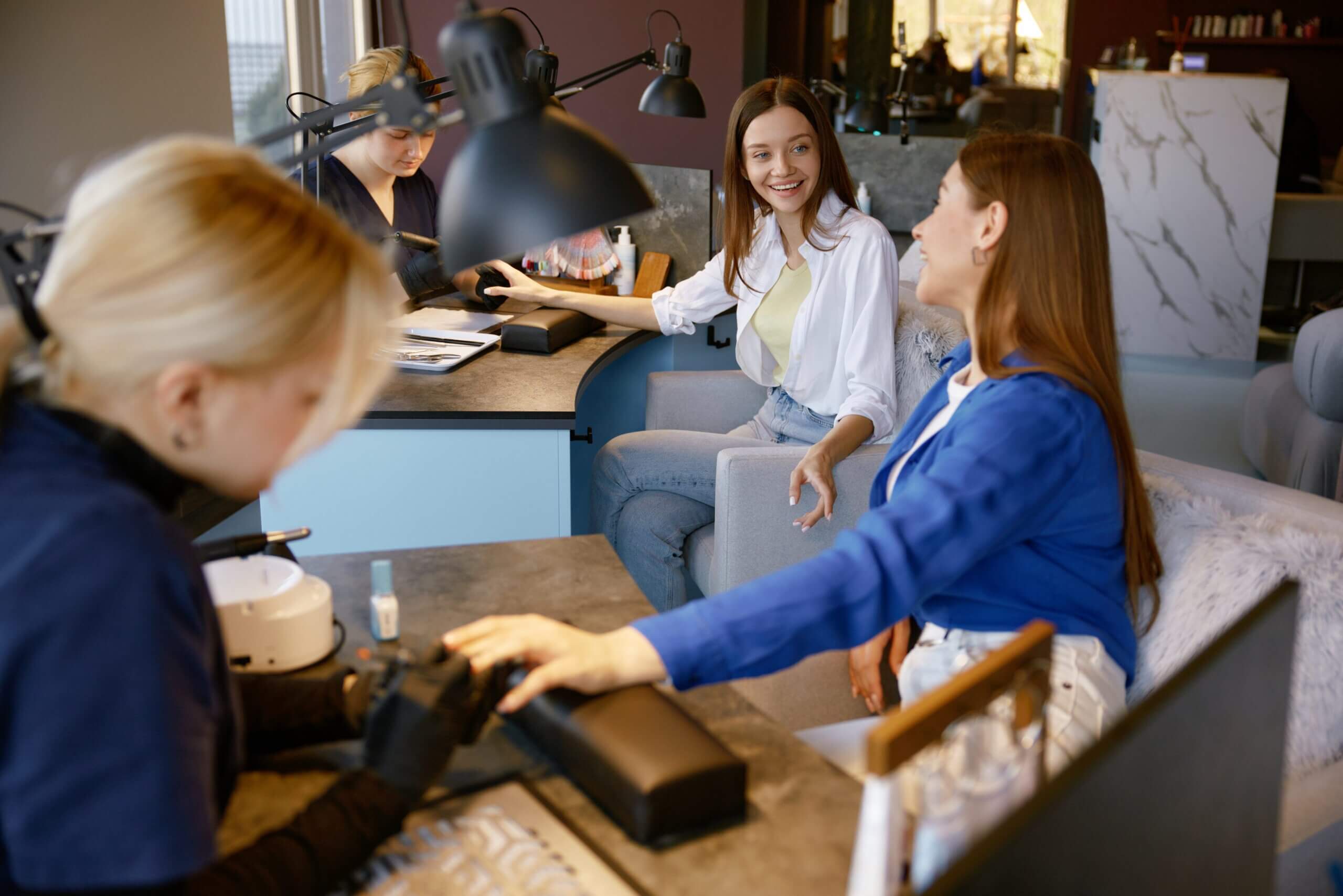 Two ladies happily talking and enjoying each other's company while getting their manicures